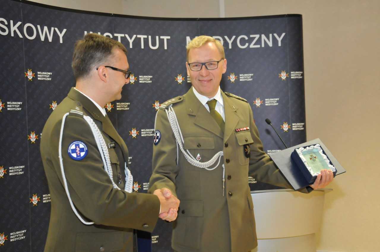Uroczystość wręczenia Nagród Dyrektora WIM. Grzegorz Gielerak wręcza nagrodę laureatowi.