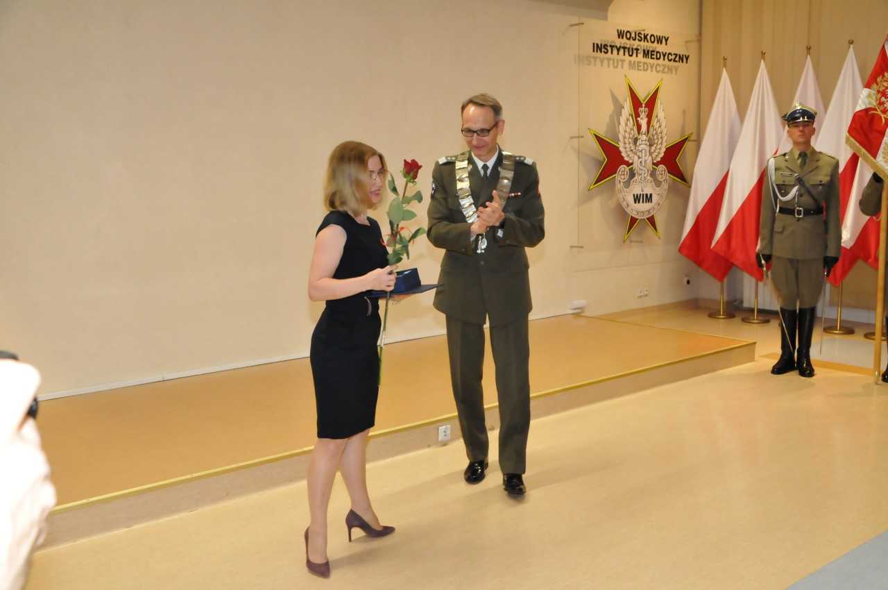 dr hab. Beata Uziębło-Życzkowska z różą i dyplomem w reku, obok niej Grzegorz Gielerak dyrektor WIM.