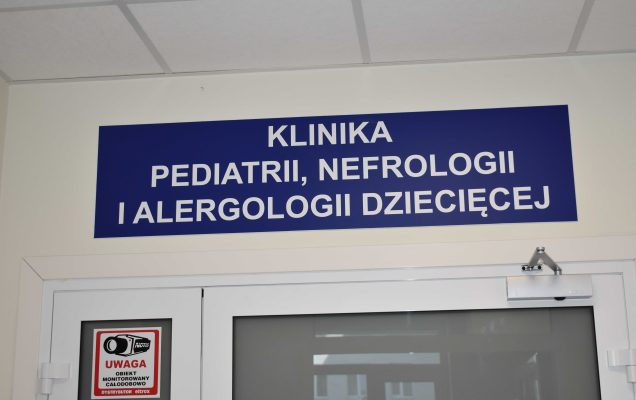 Wejście i tablica informacyjna nad drzwiami do Kliniki Pediatrii Nefrologii i Alergologi Dziecięcej