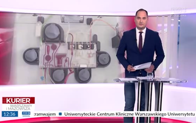 Zrzut ekrany programu telewizyjnego Kurier Warszawy i Mazowsza, N a pierwszym planie prezenter wtle studio telewizyjne