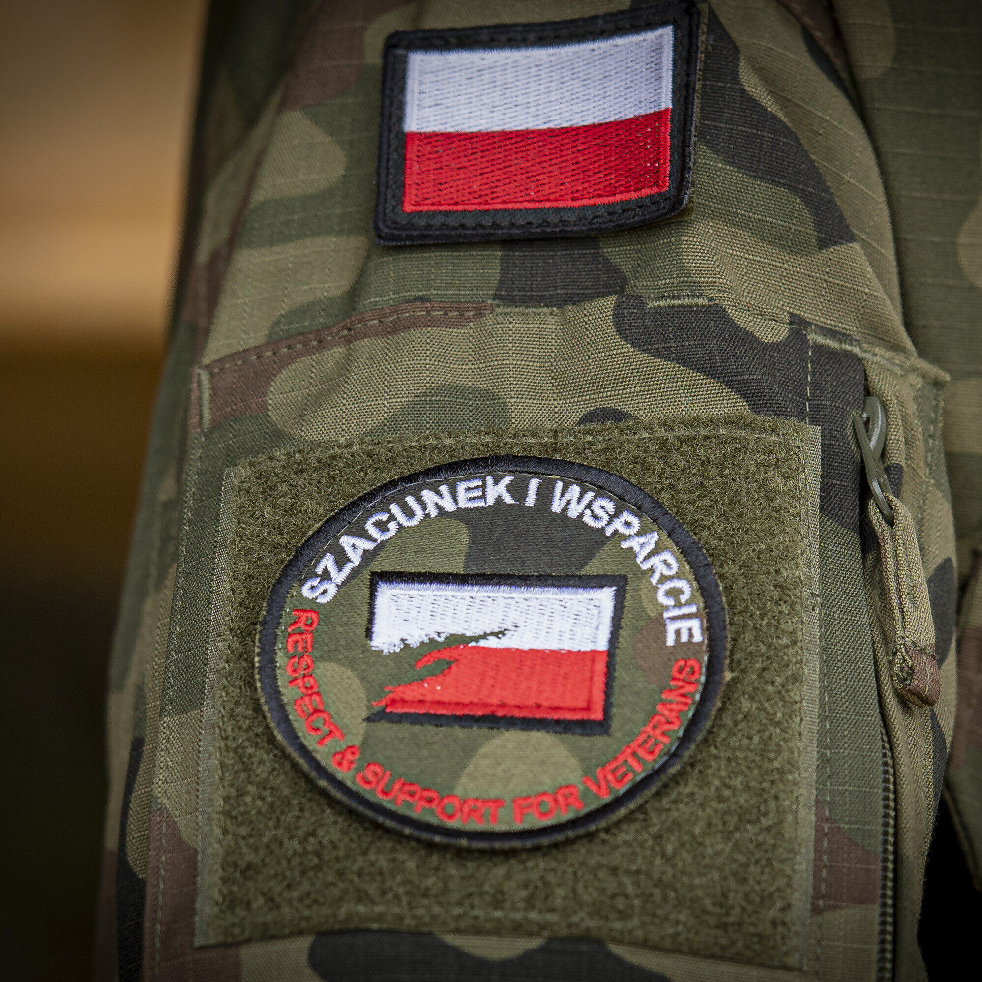 Fragment ramienia w mundurze wojskowym z naszywką na mundurze szacunek i wsparcie