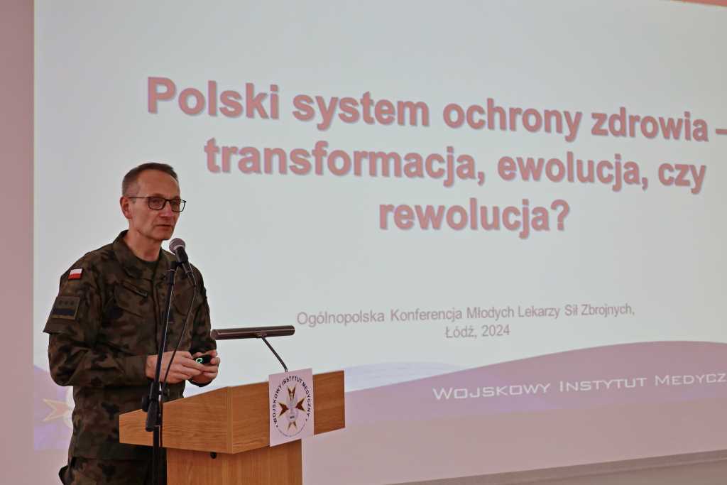 VIII Ogólnopolska Konferencja Młodych Lekarzy Sił Zbrojnych, Grzegorz Gielerak podczas wykładu, za plecami napis z rzutnika 