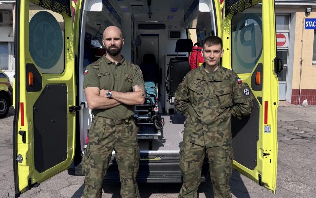 Ratownicy medyczny przed otwartym ambulansem