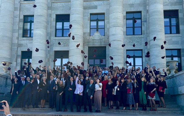 Naukowcy podrzucające czapki przed budynkiem Harvard Medicine School