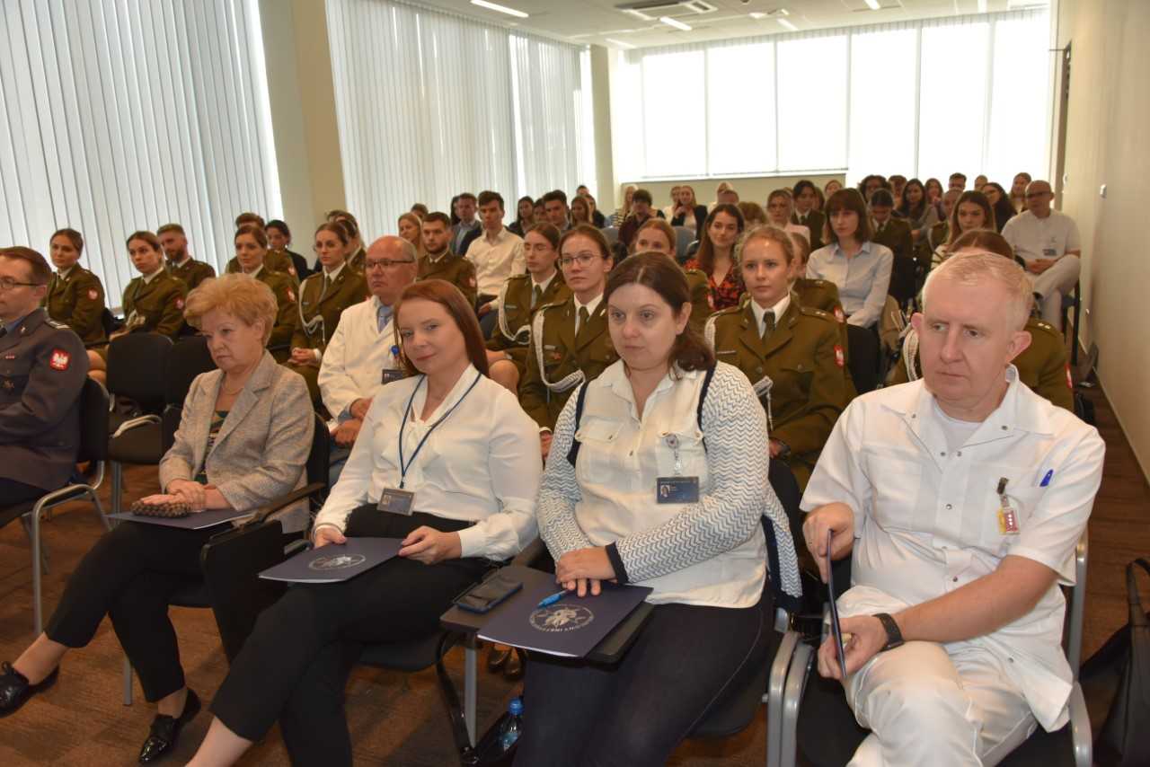 Studenci i pracownicy WIM-PIB na sali podczas inauguracji roku akademickiego w Wojskowym Instytucie Medycznym.