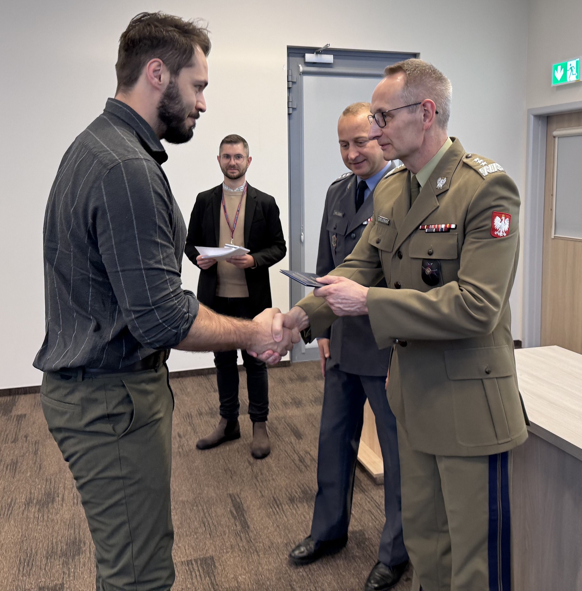 Inauguracja studiów podyplomowych w WIM-PIB. Dyrektor Grzegorz Gielerak wręcza dyplom studencki.