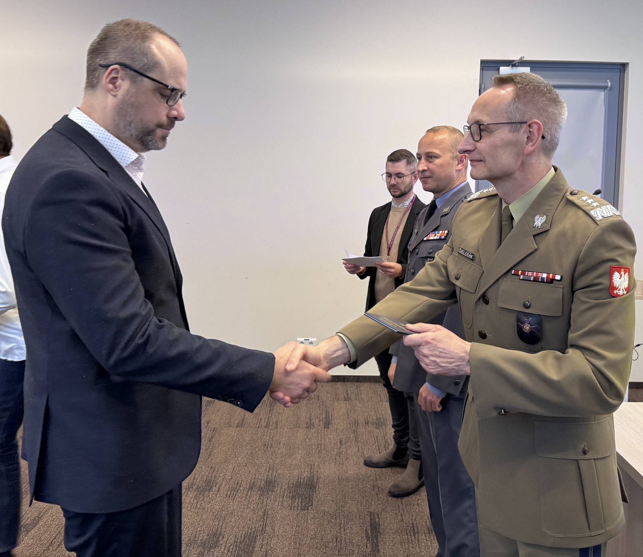 Inauguracja studiów podyplomowych w WIM-PIB. Dyrektor Grzegorz Gielerak wręcza dyplom studencki.