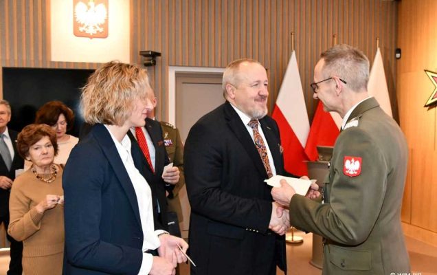 Spotkanie wigilijne w Wojskowym Instytucie Medycznym w Warszawie. Uczestnicy spotkania dzielą się opłatkiem z dyrektorem WIM Grzegorzem Gielerakiem na Auli.