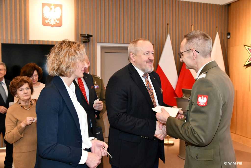 Spotkanie wigilijne w Wojskowym Instytucie Medycznym w Warszawie. Uczestnicy spotkania dzielą się opłatkiem z dyrektorem WIM Grzegorzem Gielerakiem na Auli.