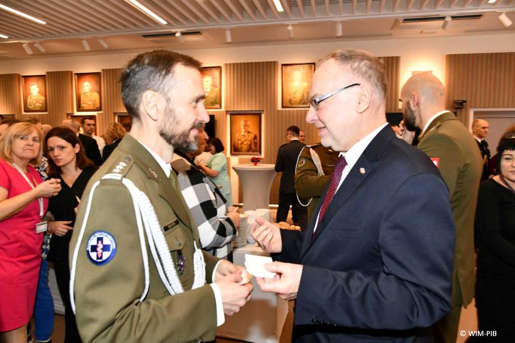 Spotkanie wigilijne w Wojskowym Instytucie Medycznym w Warszawie. Uczestnicy spotkania dzielą się opłatkiem.