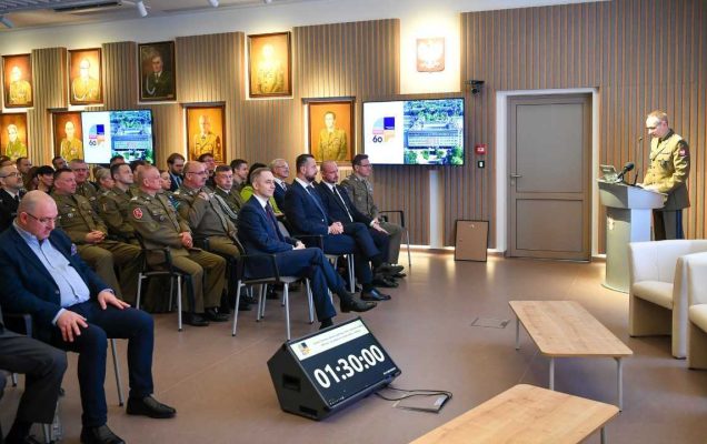 Zdjęcie kolorowe. Uroczystość 60 lecia WIM. Aula Wojskowego Instytutu Medycznego wypełniona siedzącymi gośćmi.