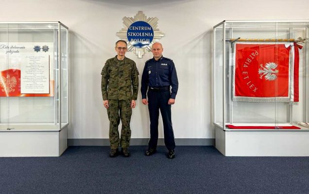 Generał broni prof. dr hab. Grzegorz Gielerak i insp. Ryszard Jakubowski Komendant Centrum Szkolenia Policji w Legionowie pozują do zdjęcia. Za nimi napis Centrum Szkolenia Policji.