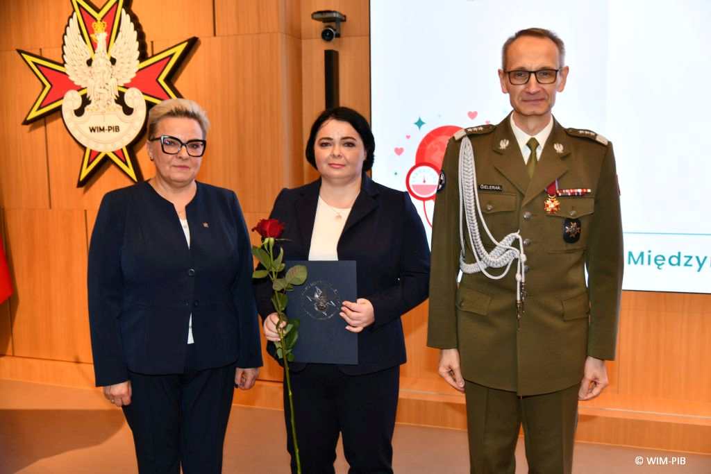 Dyrektor WIM Grzegorz Gielerak i Lidia Wojda wręczają odznaczenia i dyplomy.