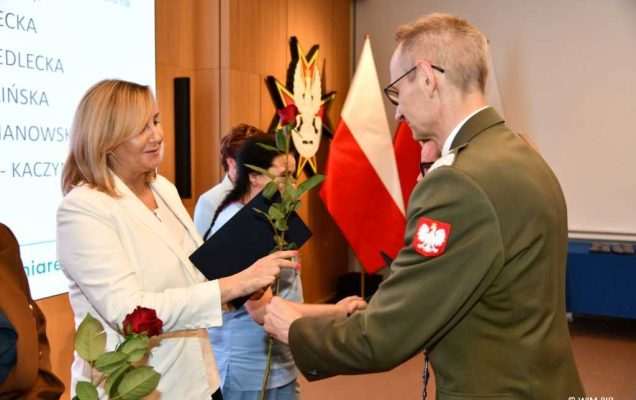 Dyrektor WIM Grzegorz Gielerak i Lidia Wojda wręczają odznaczenia i dyplomy.