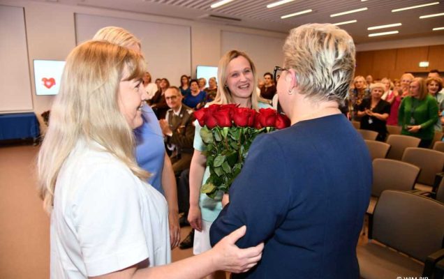 Lidia Wojda z bukietem róż i pielęgniarki.
