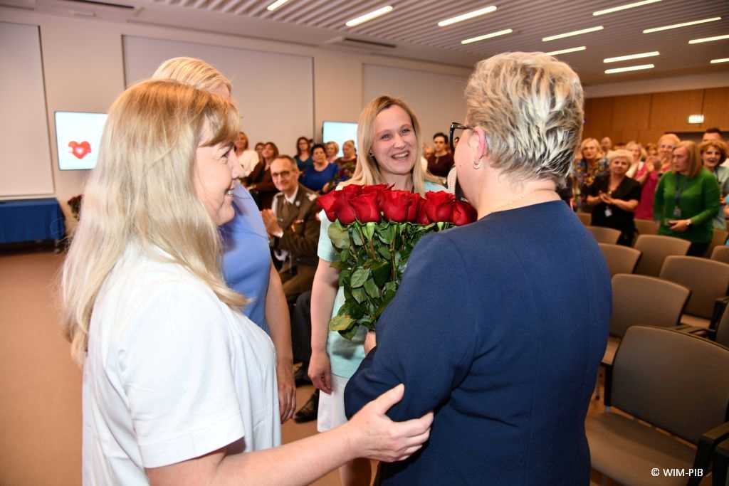 Lidia Wojda z bukietem róż i pielęgniarki.