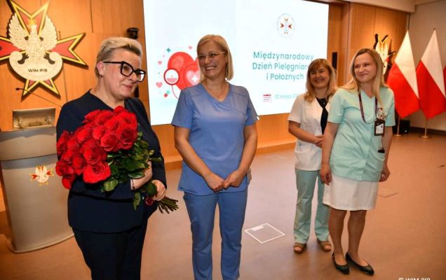 Lidia Wojda z bukietem róż i pielęgniarki.