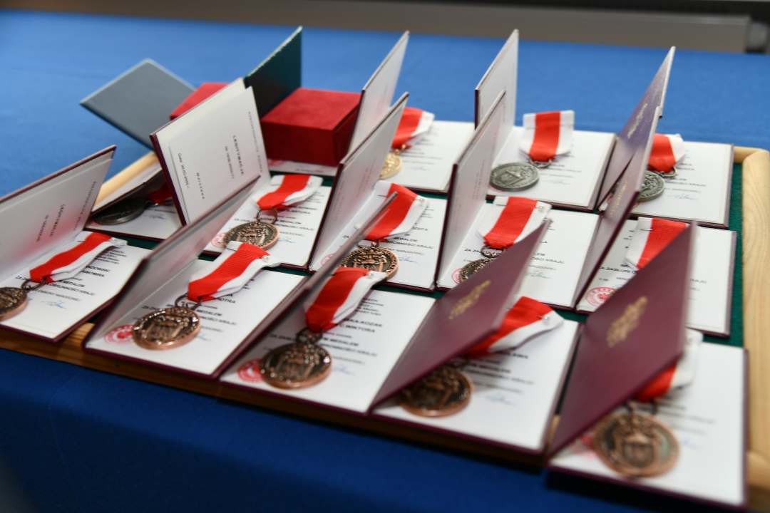 Odznaczenia na stole pokrytym granatowym suknem.