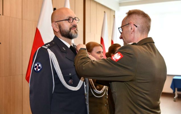 Grzegorz Gielerak wręcza odznaczenie Piotrowi Zięcinie.