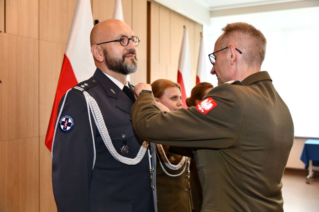 Grzegorz Gielerak wręcza odznaczenie Piotrowi Zięcinie.