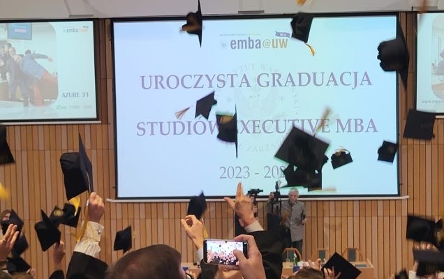 Studenci podrzucają czapki studenckie.