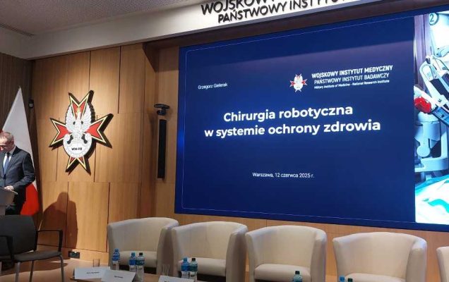 Dyrektor WIM-PIB przy mównicy. Za jego plecami wyświetlany fragment prezentacji.