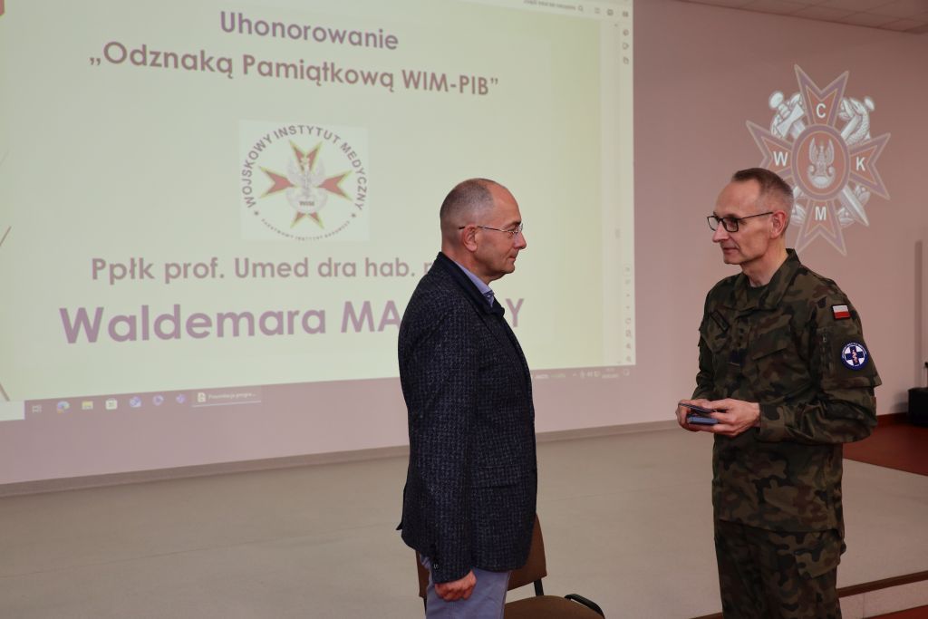 Dyrektor WIM-PIB podczas konferencji wręcza odznakę prof. Waldemarowi Machale.