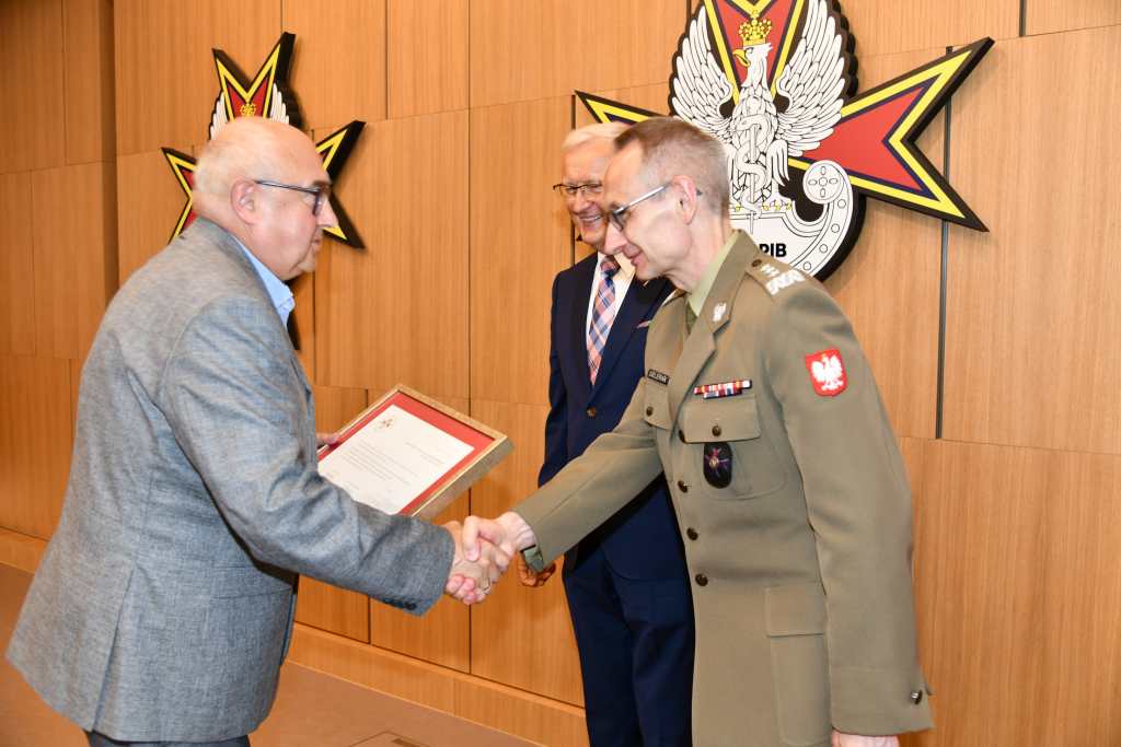Wojciech Marczyński i Grzegorz Gielerak wręczają dyplom członkowi Rady.