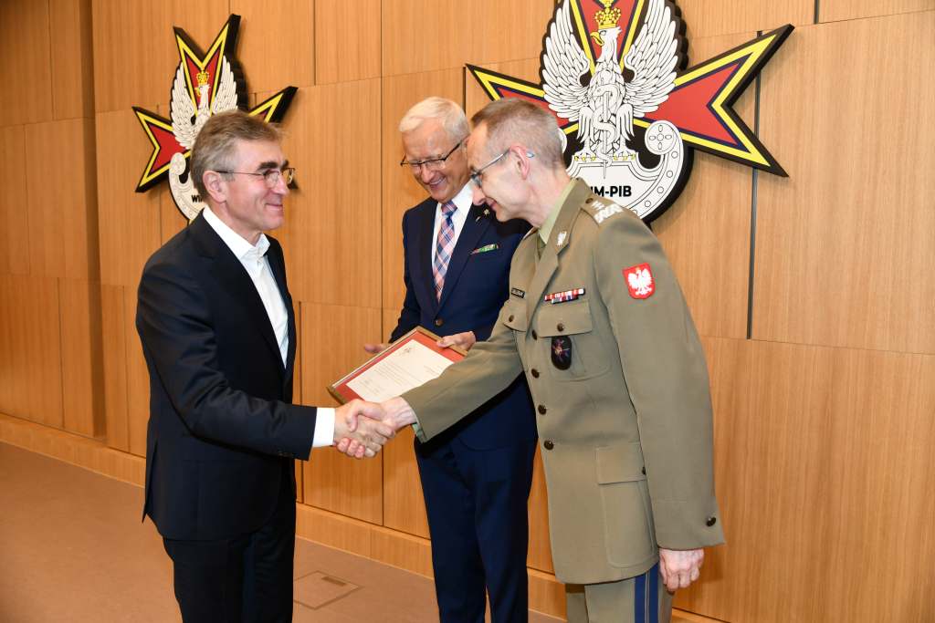Wojciech Marczyński i Grzegorz Gielerak wręczają dyplom członkowi Rady.