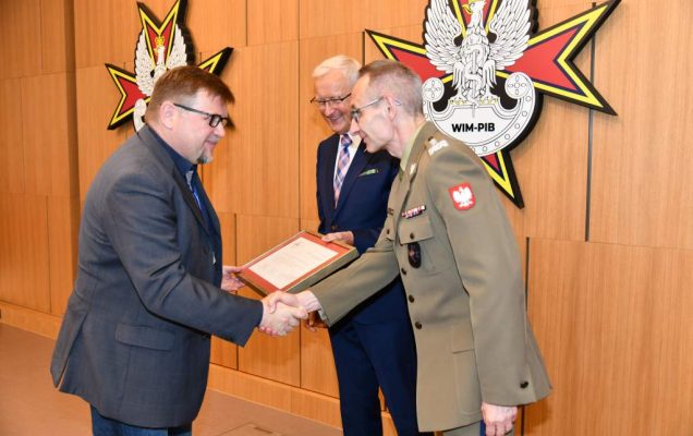 Wojciech Marczyński i Grzegorz Gielerak wręczają dyplom członkowi Rady.