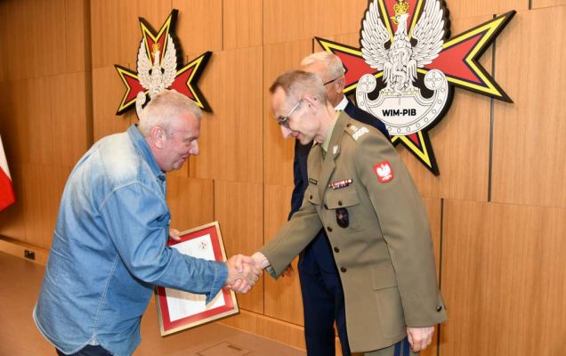 Wojciech Marczyński i Grzegorz Gielerak wręczają dyplom członkowi Rady.