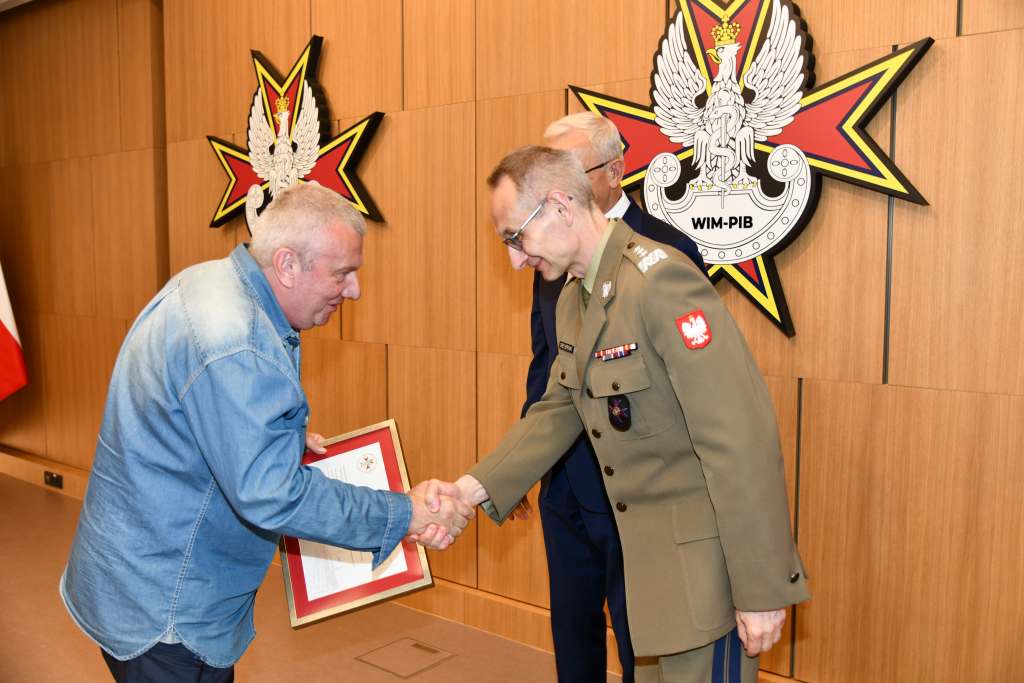 Wojciech Marczyński i Grzegorz Gielerak wręczają dyplom członkowi Rady.
