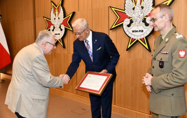 Wojciech Marczyński i Grzegorz Gielerak wręczają dyplom członkowi Rady.