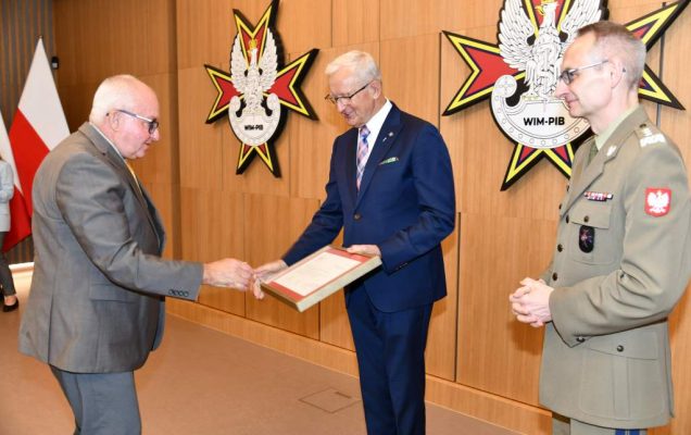 Wojciech Marczyński i Grzegorz Gielerak wręczają dyplom członkowi Rady.