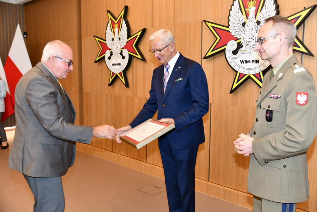 Wojciech Marczyński i Grzegorz Gielerak wręczają dyplom członkowi Rady.