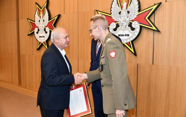 Wojciech Marczyński i Grzegorz Gielerak wręczają dyplom członkowi Rady.
