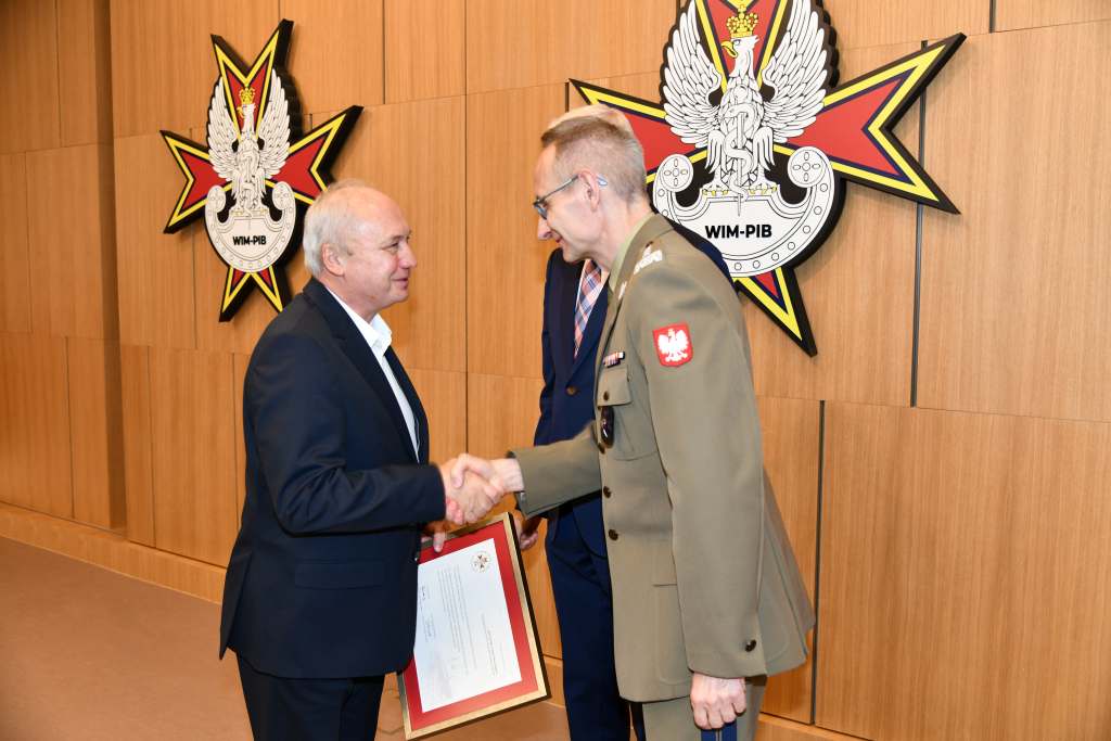 Wojciech Marczyński i Grzegorz Gielerak wręczają dyplom członkowi Rady.