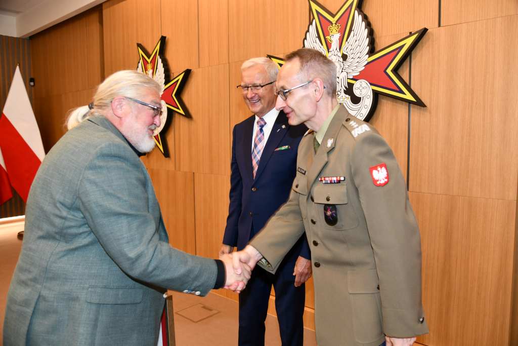 Wojciech Marczyński i Grzegorz Gielerak wręczają dyplom członkowi Rady.