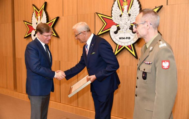 Wojciech Marczyński i Grzegorz Gielerak wręczają dyplom członkowi Rady.