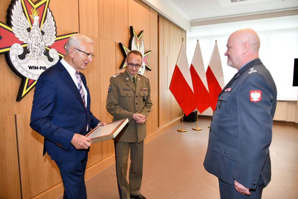 Wojciech Marczyński i Grzegorz Gielerak wręczają dyplom profesorowi Markowi Rękasowi.