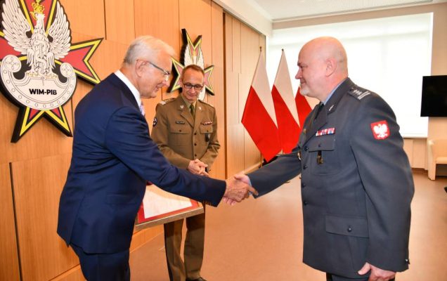 Wojciech Marczyński i Grzegorz Gielerak wręczają dyplom profesorowi Markowi Rękasowi.