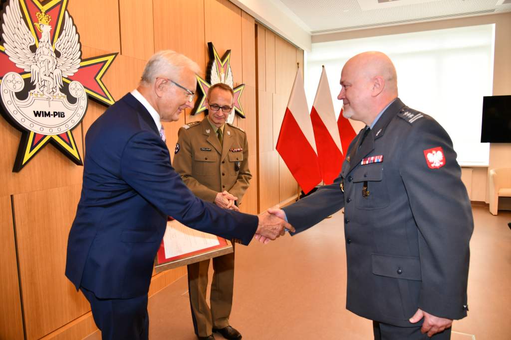 Wojciech Marczyński i Grzegorz Gielerak wręczają dyplom profesorowi Markowi Rękasowi.