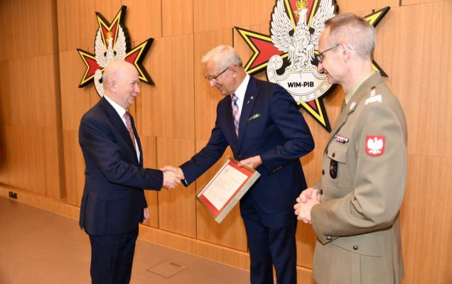 Wojciech Marczyński i Grzegorz Gielerak wręczają dyplom Bolesławowi Kalickiemu.