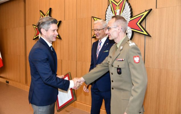 Wojciech Marczyński i Grzegorz Gielerak wręczają dyplom członkowi rady.