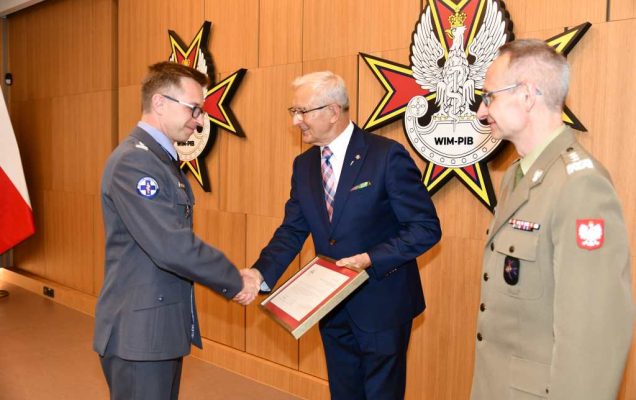 Wojciech Marczyński i Grzegorz Gielerak wręczają dyplom Grzegorzowi Kamińskiemu.