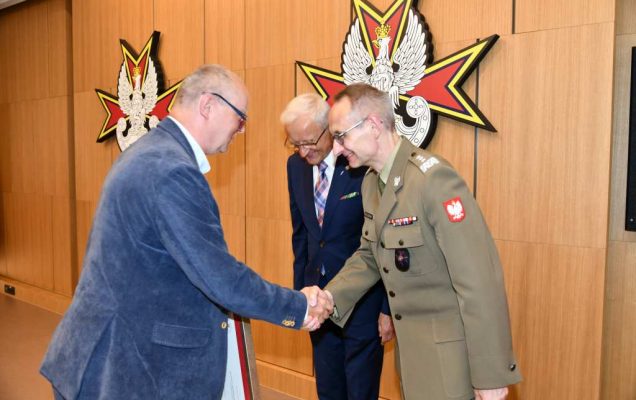 Wojciech Marczyński i Grzegorz Gielerak wręczają dyplom członkowi Rady.