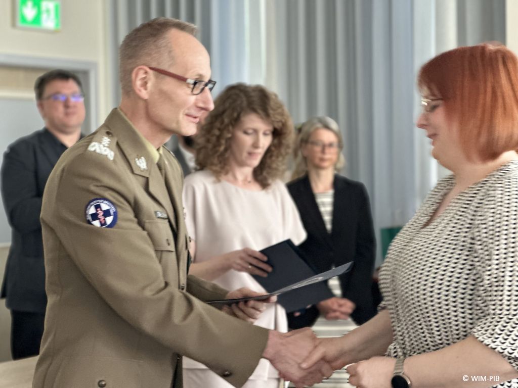 Dyrektor WIM-PIB wręcza dyplom studentce.