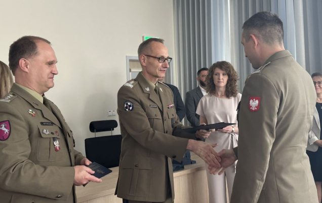 Dyrektor WIM-PIB wręcza dyplom studentowi ubranemu w wojskowy mundur.