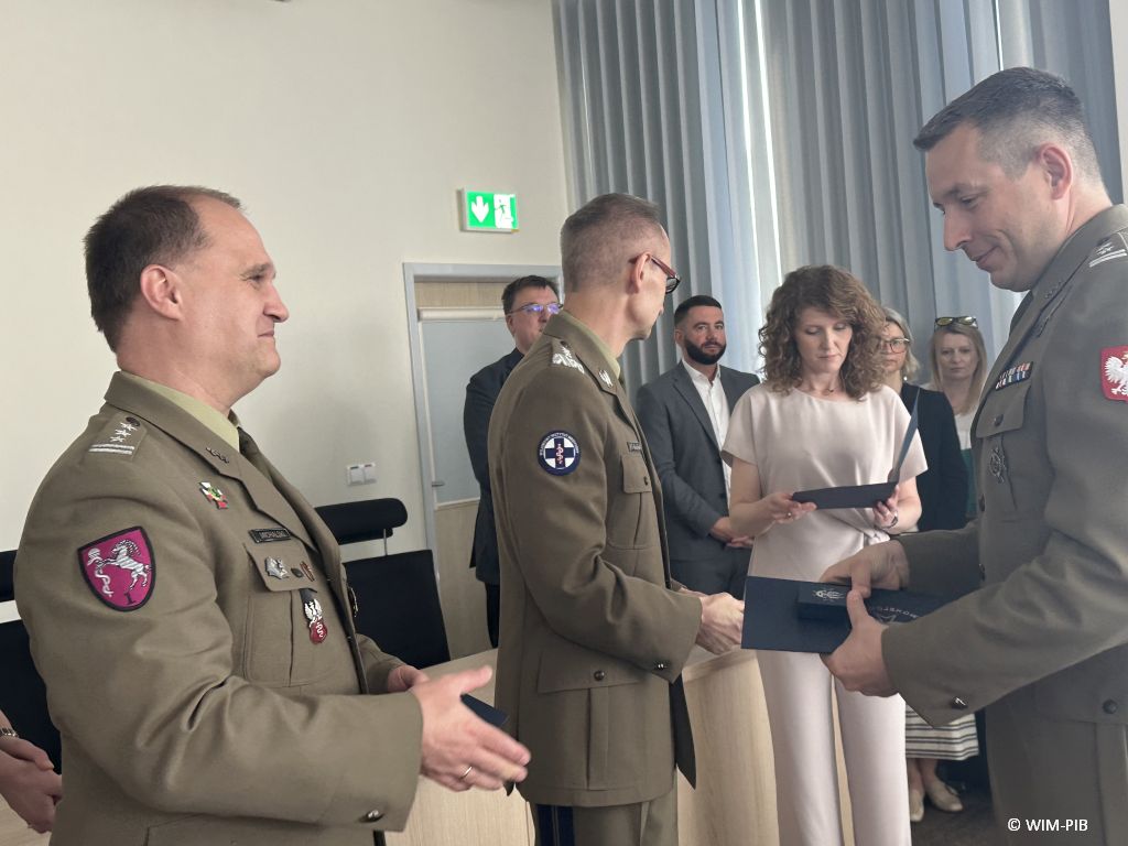 Student w mundurze wojskowym ściska rękę pracownikowi WIM-PIB ubranemu w wojskowy mundur.