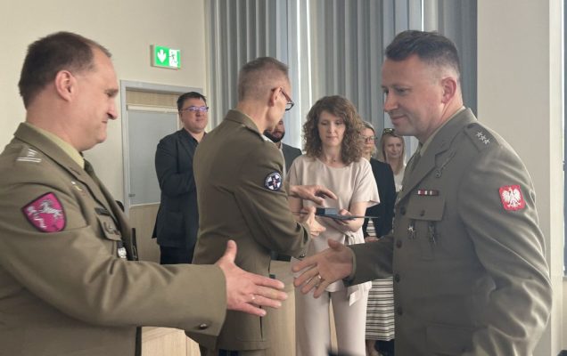 Student w mundurze wojskowym ściska rękę pracownikowi WIM-PIB ubranemu w wojskowy mundur.